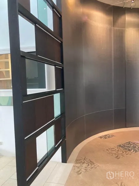 Office Space for rent in Khlong Toei, Bangkok - Curved dark feature wall beside open grid partition and accent flooring.