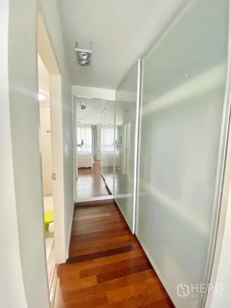 คอนโด ให้เช่าในWatthana, Bangkok - โถงทางเดินพร้อมตู้เสื้อผ้าบานเลื่อนกระจกฝ้าและกระจกเงานำสู่ห้องนอน