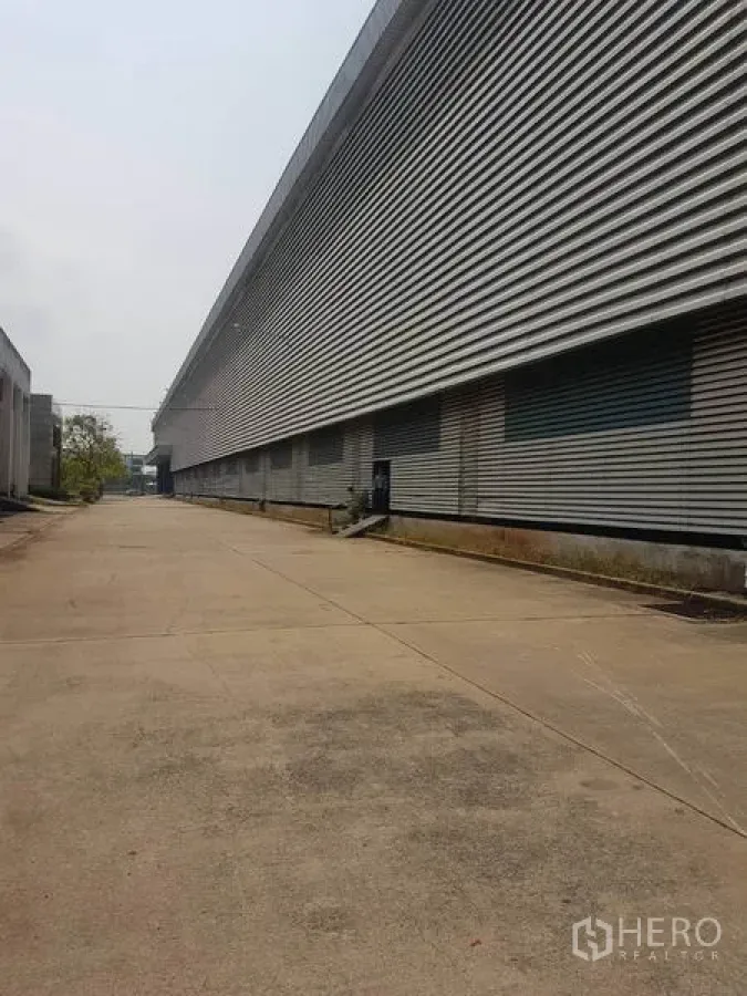 โรงงาน ให้เช่าในMueang Samut Sakhon, Samut Sakhon - ถนนคอนกรีตกว้างขนาบอาคารโรงงานผนังเมทัลชีทยาว พร้อมช่องขนถ่ายสินค้า ในสมุทรสาคร