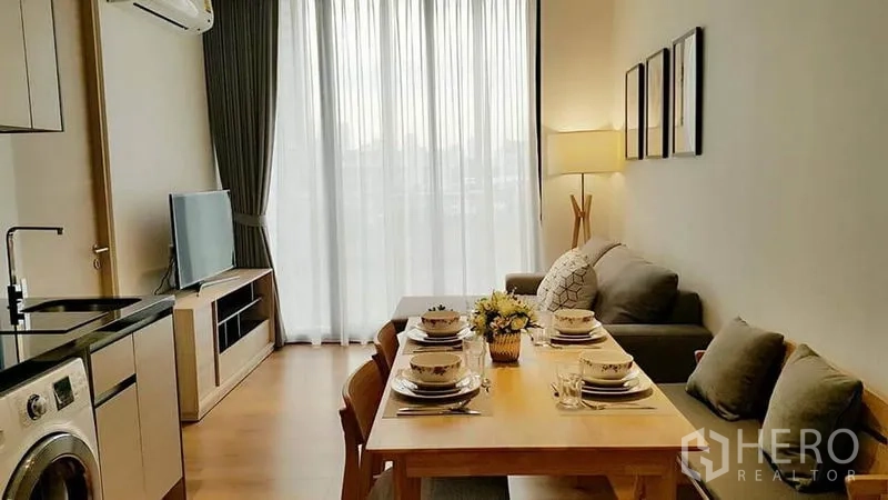 คอนโด ให้เช่าในKhlong Toei, Bangkok - ครัวและพื้นที่ทานข้าวจัดโต๊ะพร้อมใช้ เชื่อมต่อห้องนั่งเล่นและหน้าต่างสูง