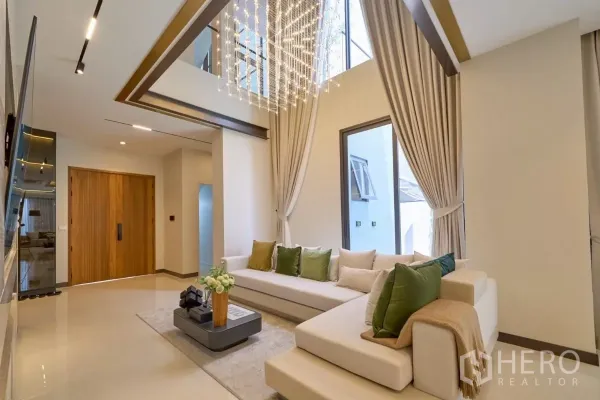 บ้าน ขายในLat Phrao, Bangkok - โถงรับแขกเพดานสูงสองชั้น พร้อมโคมระย้าดีไซน์เด่นและผ้าม่านสูงจรดเพดาน