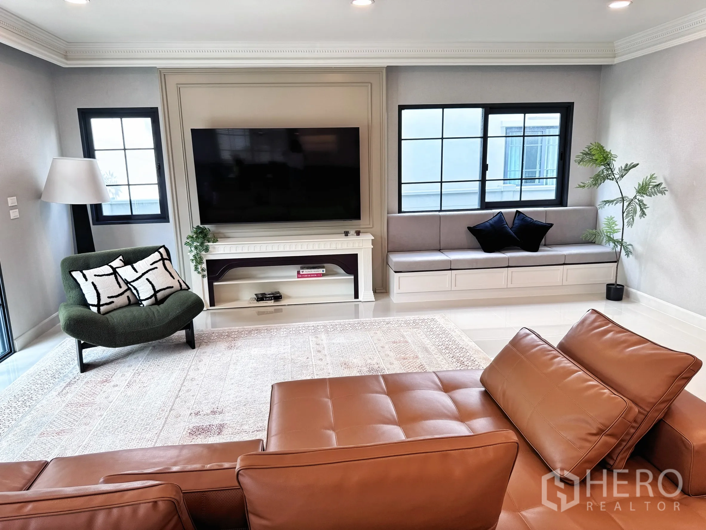 Detached House for rent in Bang Phli, Samut Prakan - Spacious lounge with leather sectional, wall-mounted TV, and window bench.