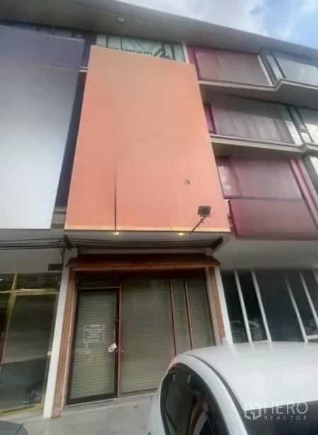 店屋 出租 - 多层店屋外立面，橙色招牌面板，上层大窗与一层卷闸门，靠近On Nut。