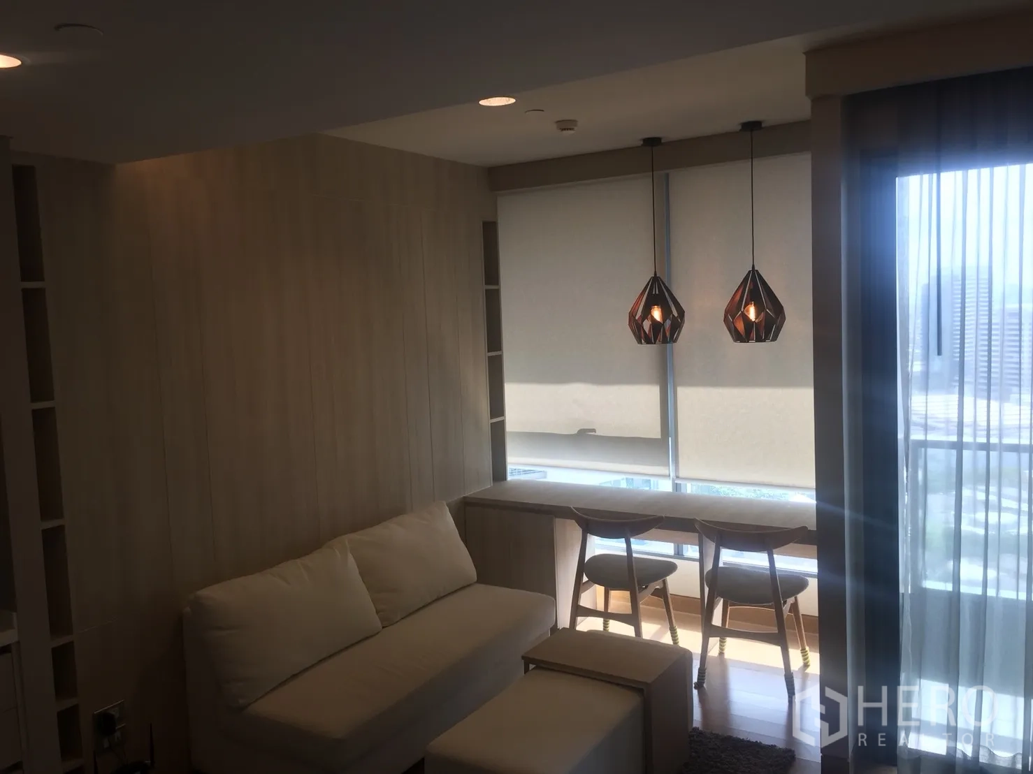 คอนโด ให้เช่าในKhlong Toei, Bangkok - พื้นที่นั่งเล่นสว่างด้วยกระจกบานใหญ่ โซฟา โคมแขวน และเคาน์เตอร์บาร์ริมหน้าต่างเห็นวิวเมือง