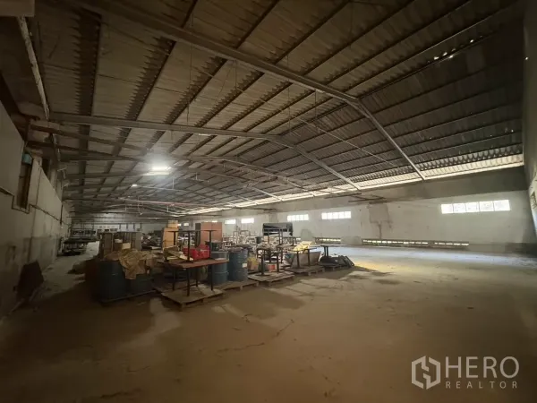 Warehouse for rent in Khlong Toei, Bangkok - Storage area inside the warehouse with pallets, drums and side windows for daylight.