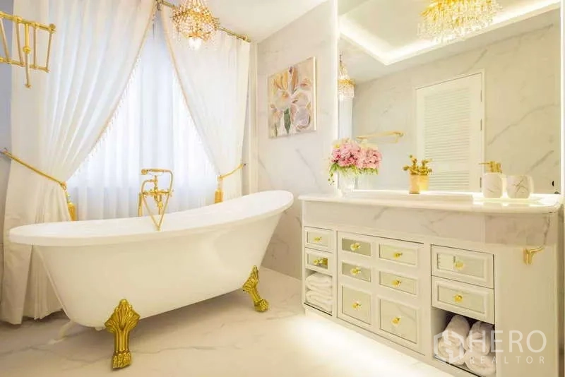 联排别墅 出租在Lat Phrao, Bangkok - 豪华浴室，独立爪足浴缸、大理石台面与金色点缀。