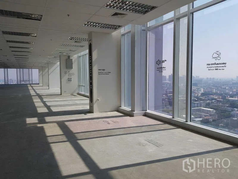 Office Space for rent - Large corner office floor in bare-shell condition with ceiling grid and panoramic floor-to-ceiling windows.