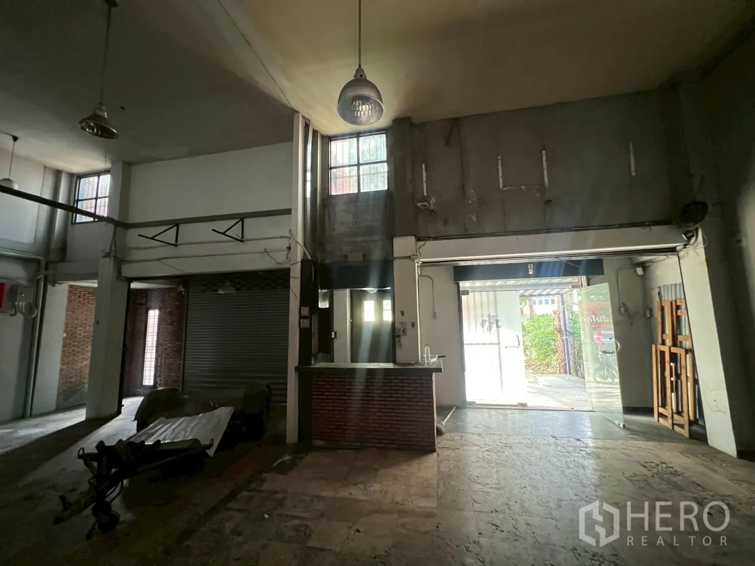 店屋 出租在Phra Khanong, Bangkok - 主大厅，接待台、卷闸门与挑高天花。