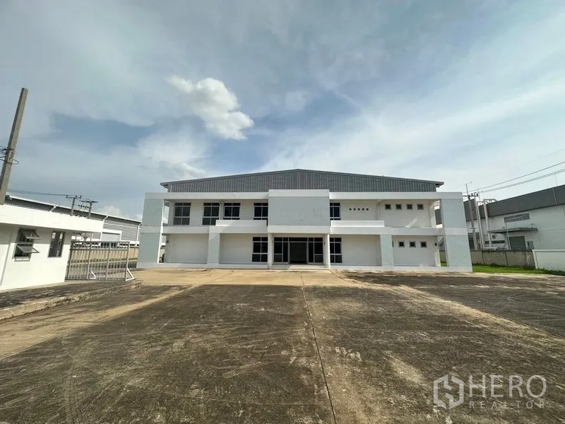 工厂 出租在Phra Nakhon Si Ayutthaya - 工厂正立面，带安保大门与宽大的混凝土回车场。