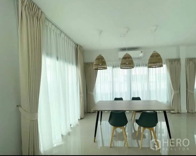 Detached House for rent in Bang Phli, Samut Prakan - Dining area with modern table, three pendant lights and full-height curtains.