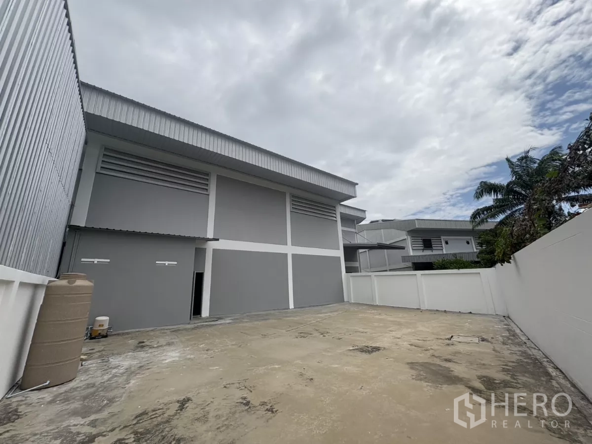 Factory for rent in Phra Samut Chedi, Samut Prakan - Back elevation of the factory with walled concrete yard for loading and parking.
