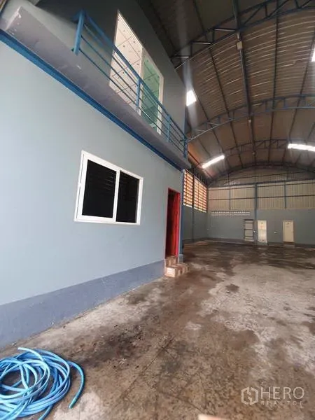货栈 出租或出售在Bang Bua Thong, Nonthaburi - 仓库内部含夹层办公室，混凝土地面与高挑拱形钢结构屋顶。
