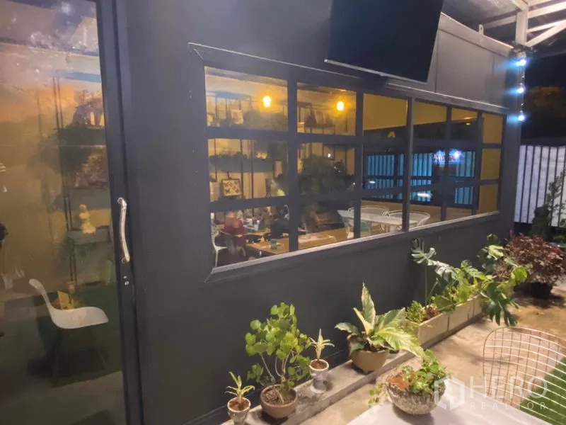 พื้นที่ขายปลีก ให้เช่าในKhlong Toei, Bangkok - ด้านนอกอาคารสีดำ หน้าต่างบานใหญ่และกระถางต้นไม้ริมเฉลียง