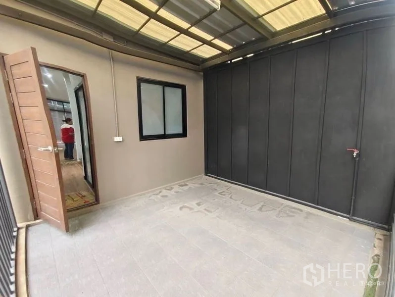 Shophouse for rent or sale in Pom Prap Sattru Phai, Bangkok - Covered terrace or utility area with tiled floor and dark privacy wall.