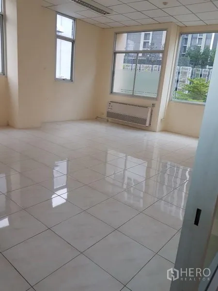 办公空间 出租在Phra Khanong, Bangkok - 开放式办公区，自然采光充足，壁挂空调、白色瓷砖地面，窗外绿景。