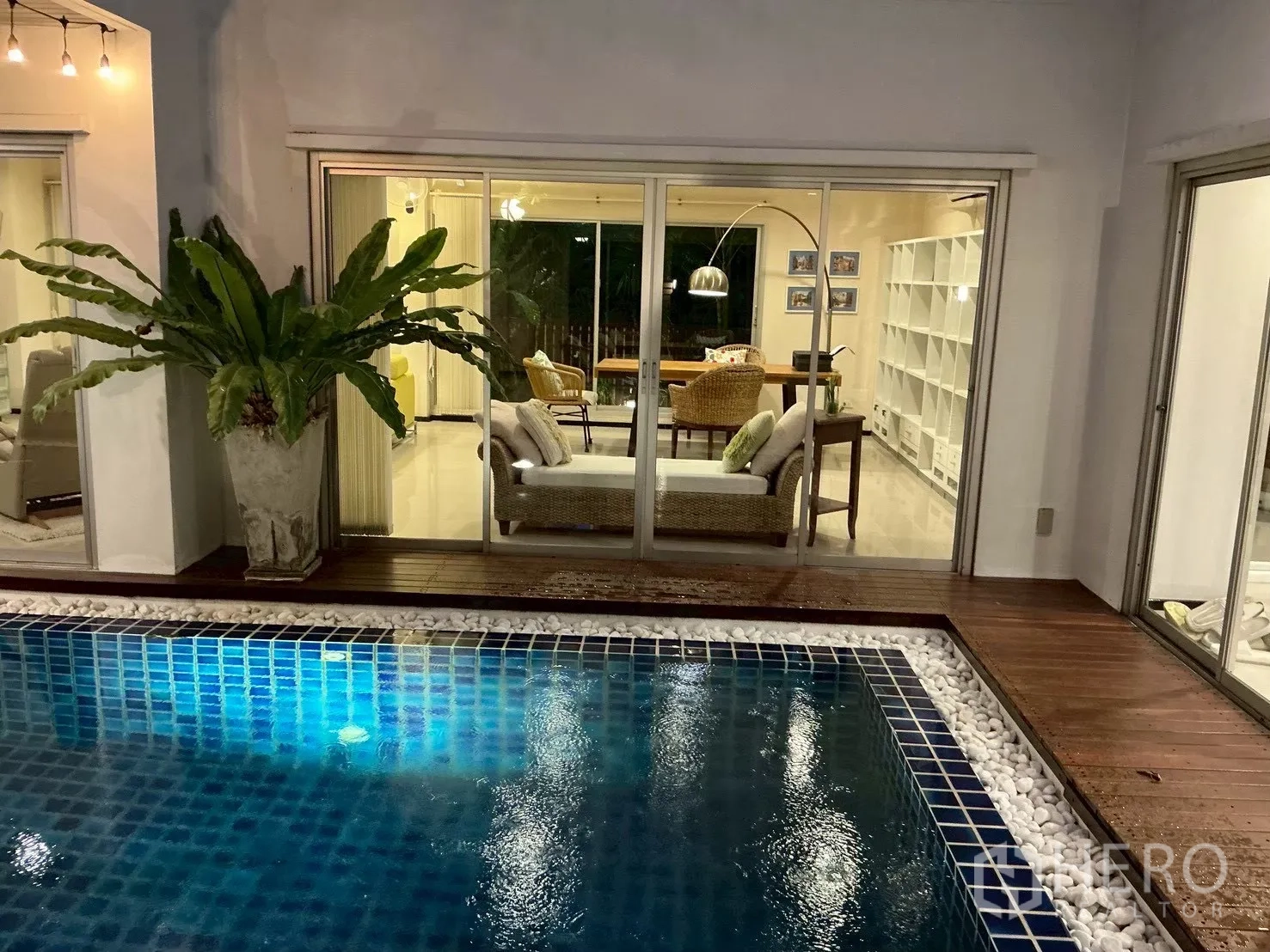 บ้านเดี่ยว for sale in Suan Luang, Bangkok - มุมมองริมสระไปยังห้องนั่งเล่นผ่านกระจกบานเลื่อนกว้าง