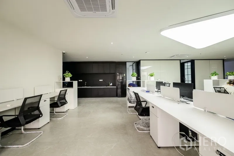 办公空间 出租或出售在Huai Khwang, Bangkok - 曼谷高层内的开放式办公室，白色工位与黑色茶水间。