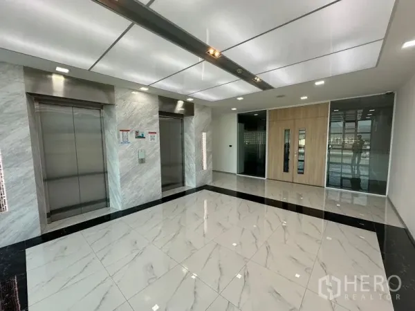 Office Space for rent - Bright elevator lobby with two stainless-steel lifts and marble-look floors.
