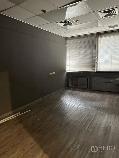 Office Space for rent in Watthana, Bangkok - Compact room with wood-look flooring, blinds and dark walls