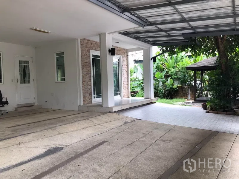 Detached House for rent in Khlong Sam Wa, Bangkok - Covered parking area beside the house with tiled terrace and a garden pavilion.