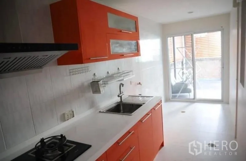 Detached House for rent in Suan Luang, Bangkok - Galley kitchen looking toward a sliding door that opens to the service yard.