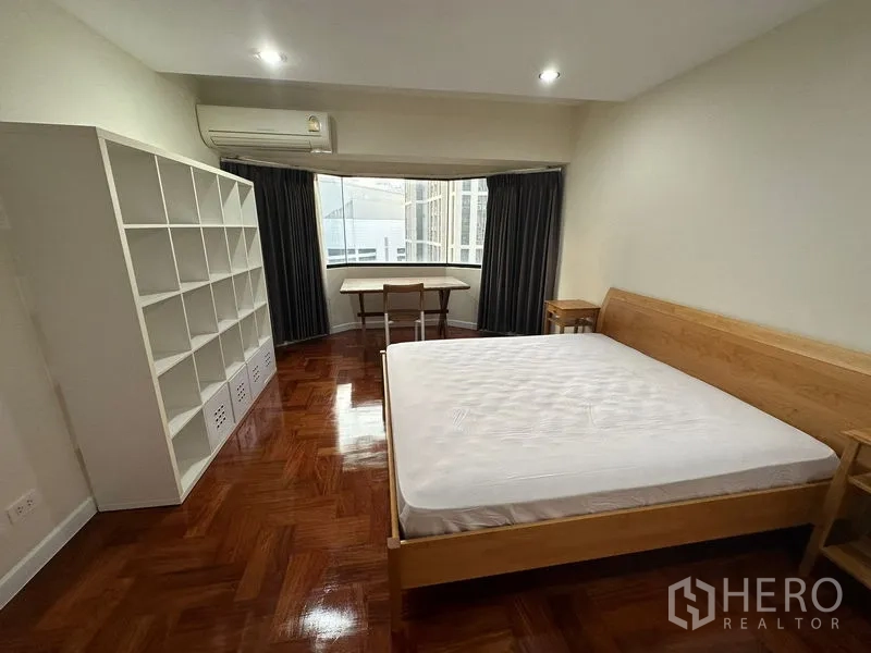 คอนโด ให้เช่าในWatthana, Bangkok - ห้องนอนพร้อมมุมหน้าต่าง Bay Window ชั้นวางขนาดใหญ่ โต๊ะทำงาน และเครื่องปรับอากาศ