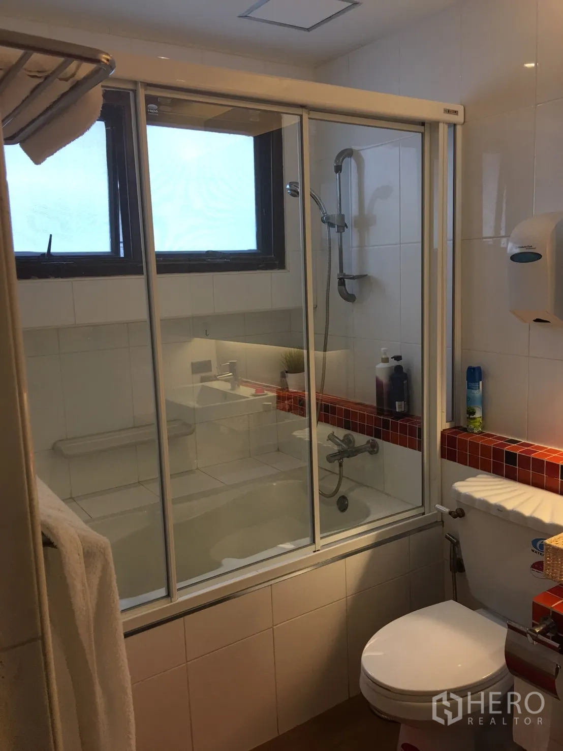 公寓 出租在Bang Rak, Bangkok - 卫浴设玻璃浴缸隔间、手持花洒与白色瓷砖。