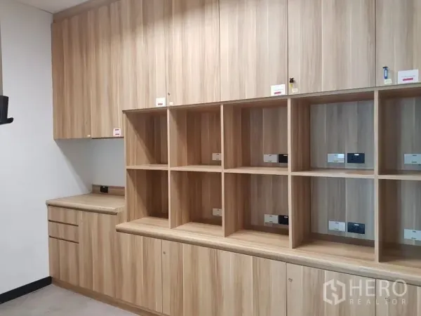 สำนักงาน ให้เช่าในHuai Khwang, Bangkok - ตู้บิลท์อินลายไม้พร้อมช่องเก็บของและปลั๊กไฟในมุมจัดเก็บของสำนักงานสมัยใหม่