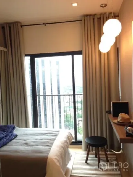 คอนโด ให้เช่าในPhaya Thai, Bangkok - ห้องนอนพร้อมประตูกระจกบานเลื่อนออกระเบียง ม่านทึบ และโคมไฟทรงกลม