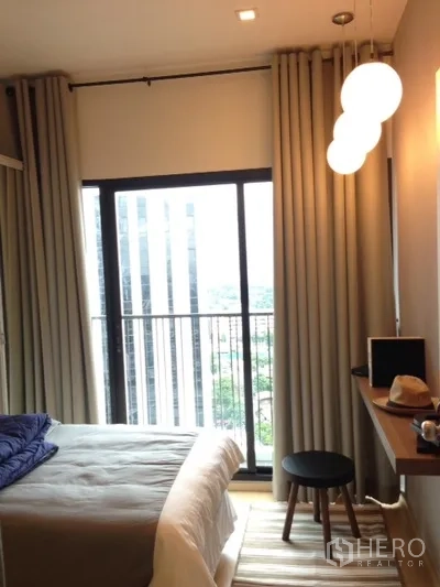 คอนโด ให้เช่าในPhaya Thai, Bangkok - ห้องนอนพร้อมประตูกระจกบานเลื่อนออกระเบียง ม่านทึบ และโคมไฟทรงกลม