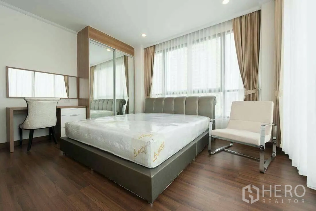 Condominium for rent in Sathon, Bangkok - Corner master bedroom with mirrored wardrobe, work desk and expansive windows.