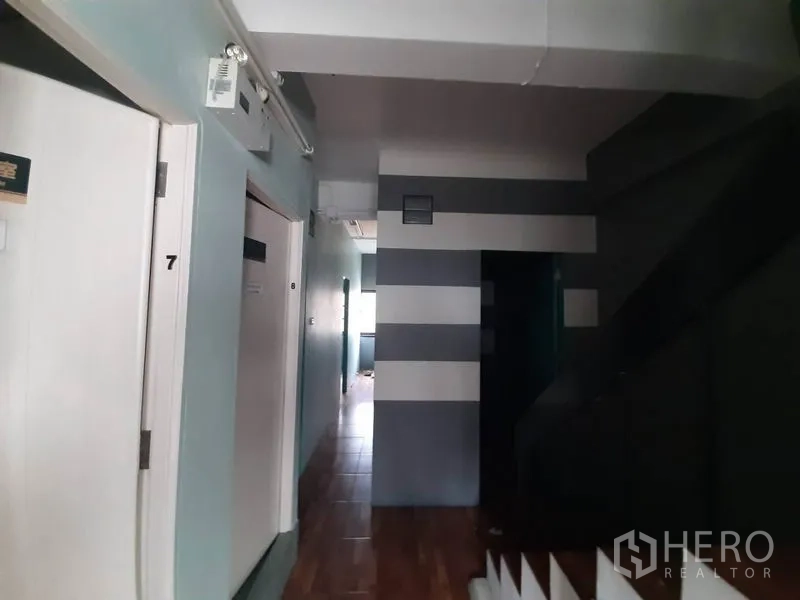 อาคารพาณิชย์ ให้เช่าในWatthana, Bangkok - ทางเดินมีประตูหมายเลข ผนังลายแถบ และบันได พื้นลายไม้