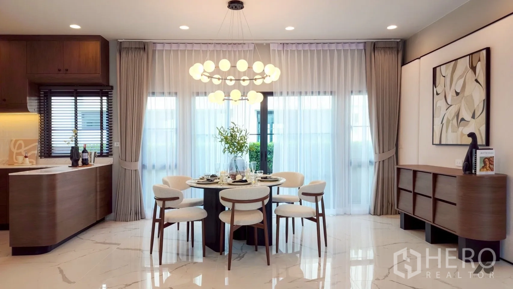 Detached House for rent in Bang Phli, Samut Prakan - Open dining room with floor-to-ceiling curtains, round table setting, and statement chandelier.