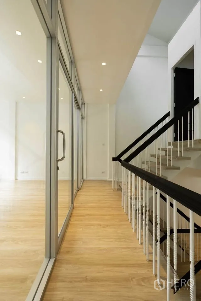 联排别墅 出租在Khlong Toei, Bangkok - 楼梯走廊，玻璃隔墙与木扶手。