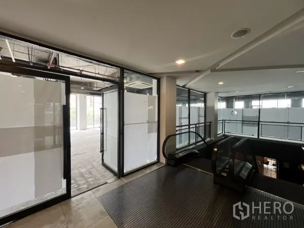 พื้นที่ขายปลีก ให้เช่าในWatthana, Bangkok - ทางเข้ารีเทลชั้น 2 พร้อมประตูกระจกและบันไดเลื่อน