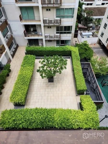 公寓 出租在Watthana, Bangkok - 自上而下俯视修剪整齐的庭院与中央绿树。