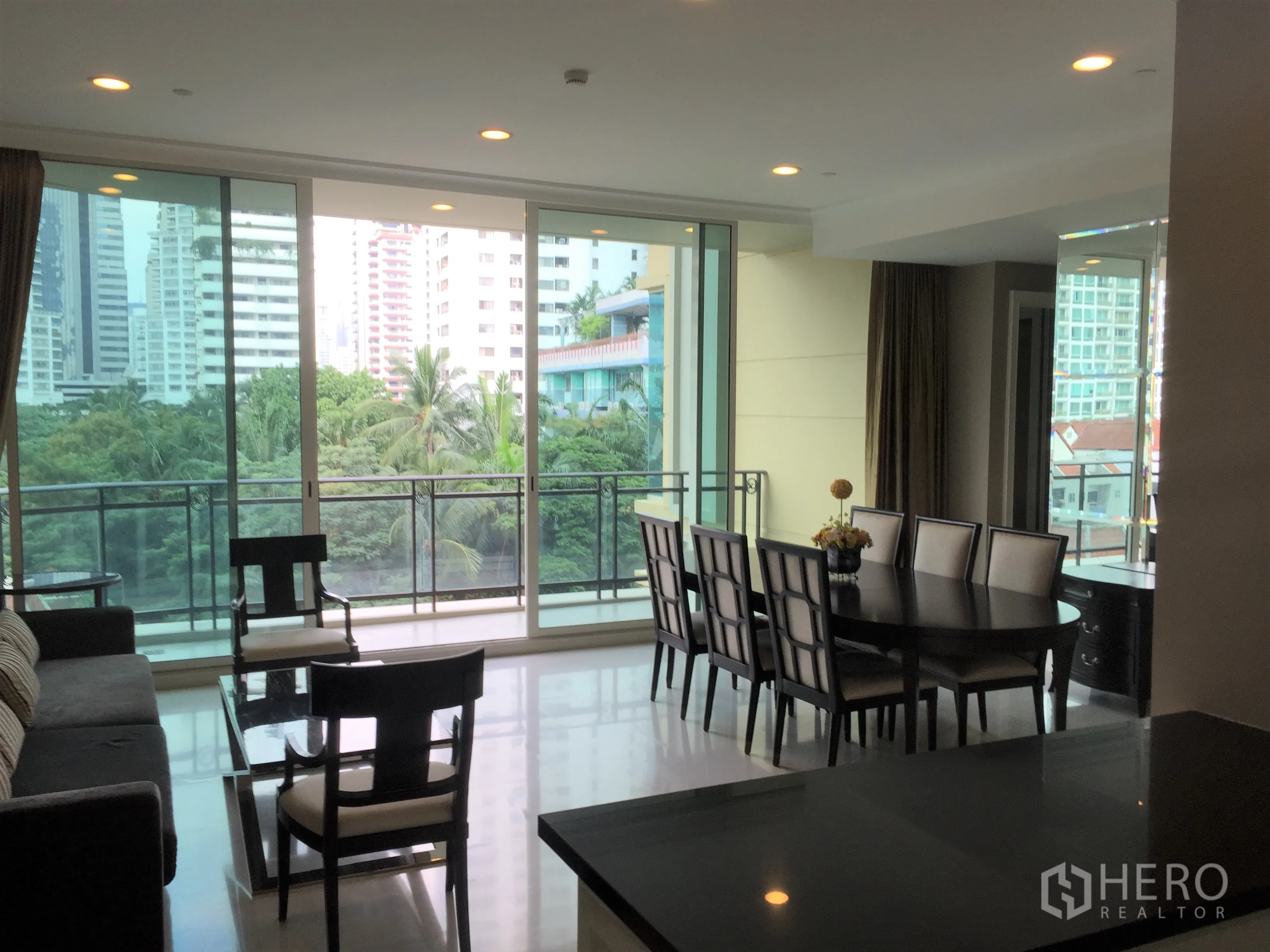 คอนโด ให้เช่าในWatthana, Bangkok - โถงนั่งเล่นต่อเนื่องกับพื้นที่ทานข้าว ผนังกระจกเต็มบาน มองเห็นต้นไม้และเมือง