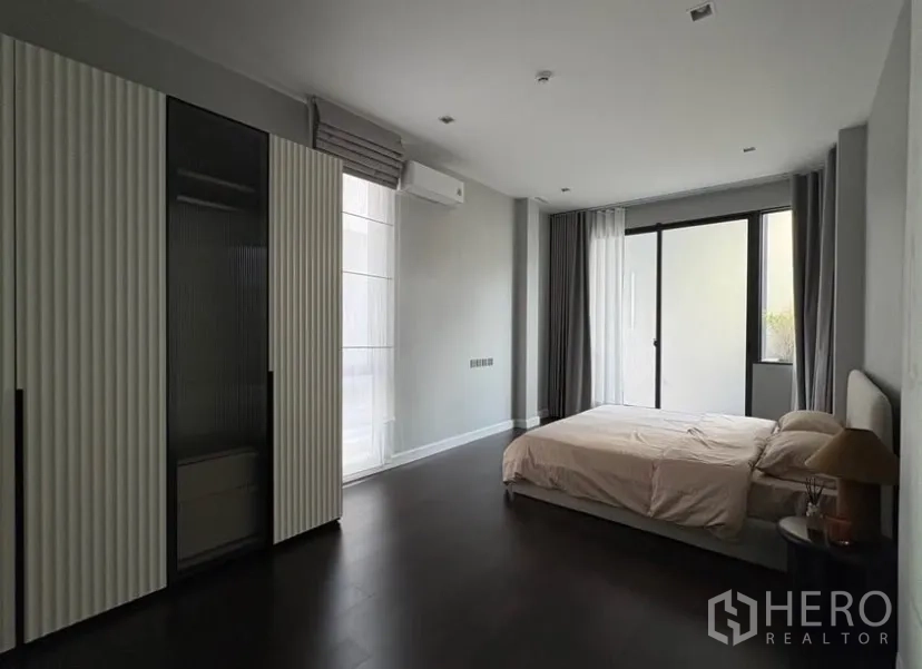 Detached House for rent in Suan Luang, Bangkok - Large bedroom with built-in wardrobes, glass sliding doors and ample natural light.