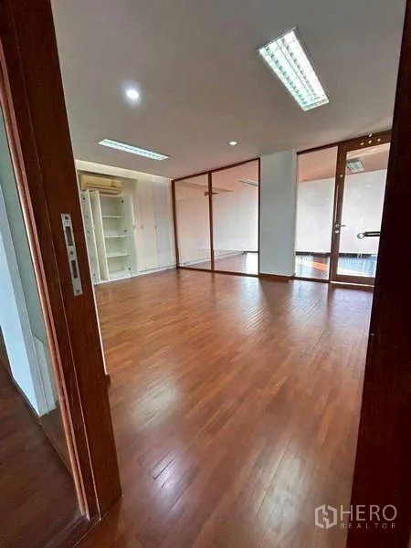 Home Office for rent or sale in Bang Phli, Samut Prakan - Spacious office room with wooden flooring, ceiling lights and full-height glass partitions.