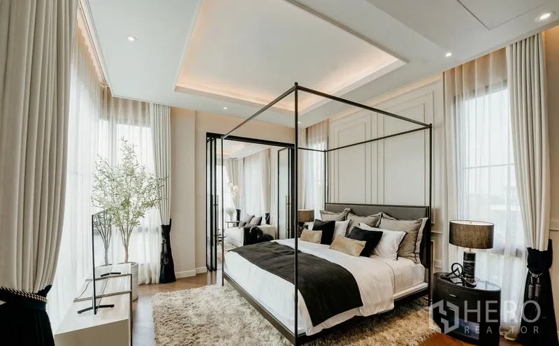 独立式住宅 出售在Saphan Sung, Bangkok - 采光充足的主卧，四柱床、大窗与中性色装饰。