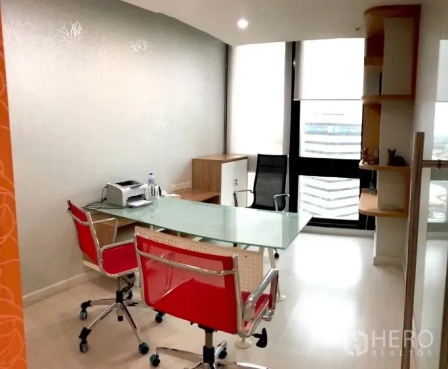 สำนักงาน ให้เช่าในBang Na, Bangkok - ห้องทำงานตกแต่งครบ โต๊ะกระจก เก้าอี้แดง และหน้าต่างสูงมองเห็นวิวเมือง