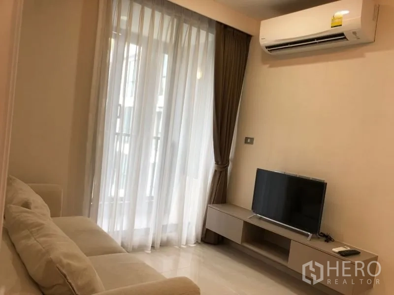 公寓 出售在Khlong Toei, Bangkok - 客厅配沙发、电视柜、空调与通向阳台的窗帘门