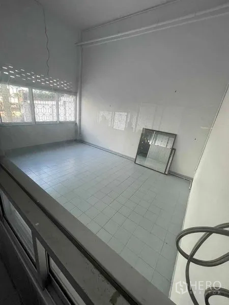 Warehouse for rent in Mueang Samut Sakhon, Samut Sakhon - Tiled office room with large windows and security grilles inside the warehouse building.