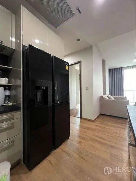 公寓 出售在Watthana, Bangkok - 厨房配大号黑色冰箱，连通客厅区域。