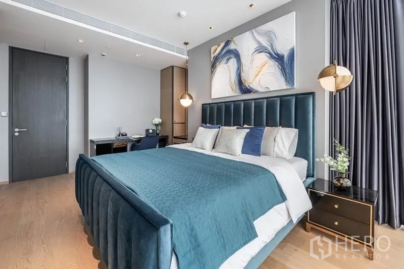 คอนโด ให้เช่าในPathum Wan, Bangkok - ห้องนอนกว้างขวาง เตียงกรอบกำมะหยี่สีเขียวอมฟ้า โต๊ะข้างเตียง และมุมทำงาน