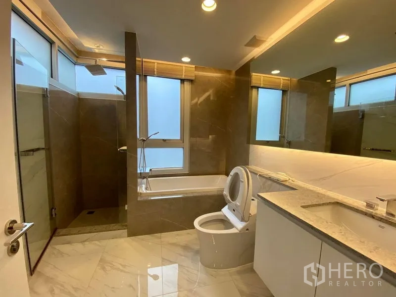 คอนโด ให้เช่าในKhlong Luang, Pathum Thani - ห้องน้ำสไตล์โมเดิร์นพร้อมอ่างอาบน้ำ ฝักบัวกระจกเงาใหญ่ และพื้นผิวหินอ่อน