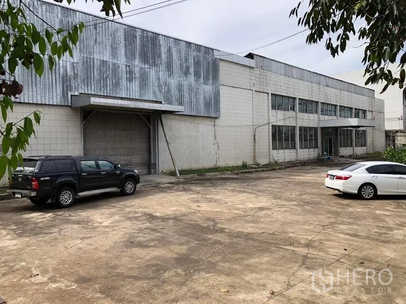 工厂 出租在Phra Pradaeng, Samut Prakan - 厂房外立面，金属包板与卷闸装卸口，配超大水泥硬地可停大车。