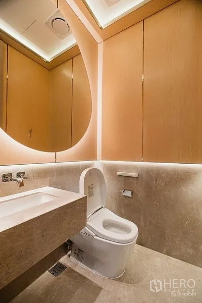 Condominium for rent - Modern powder room with backlit mirror, stone countertop and toilet.