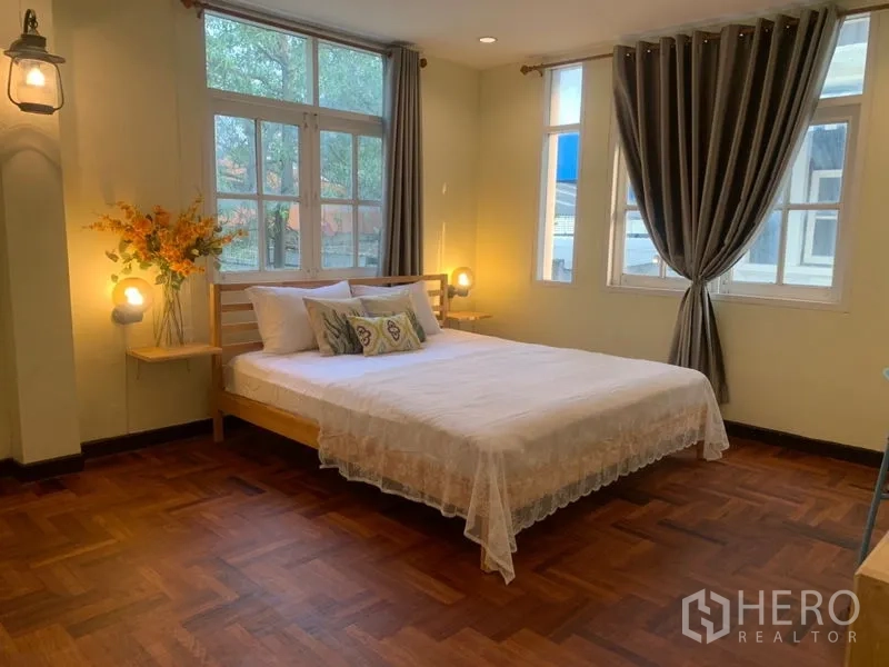 Home Office for rent in Suan Luang, Bangkok - Corner master bedroom with large windows, drapes and warm wood floors.