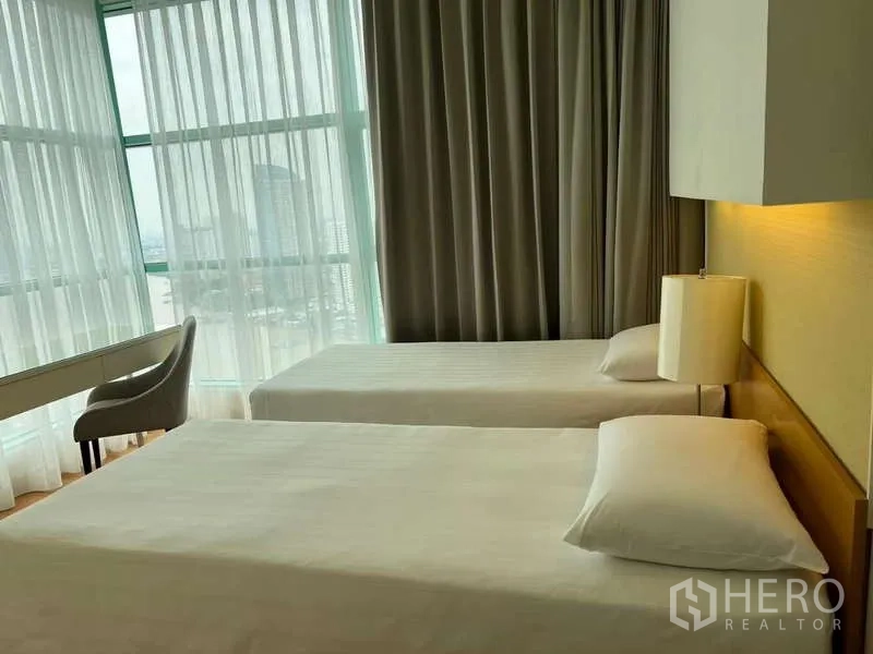 Condominium for rent in Bang Kho Laem, Bangkok - Twin bedroom with large windows and blackout curtains.